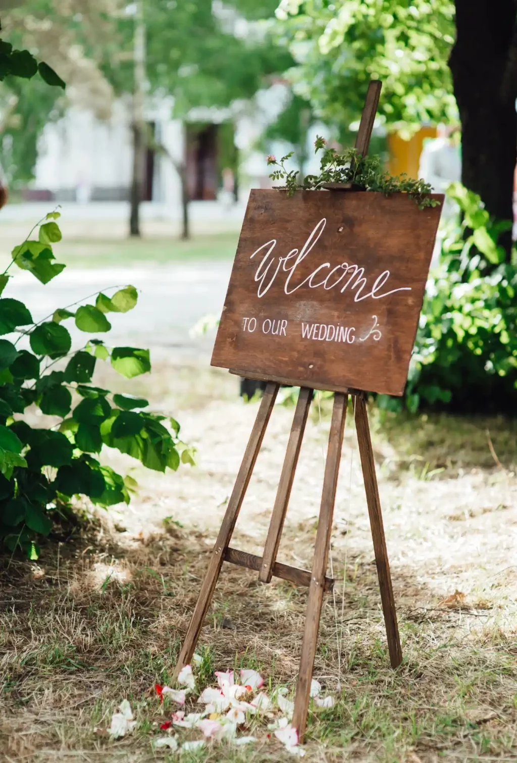 A wooden easel with a welcome to our wedding sign on it.