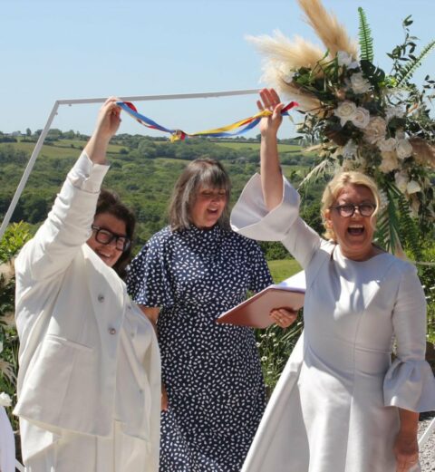 Two brides in a handfasting celebration during their humanist wedding.